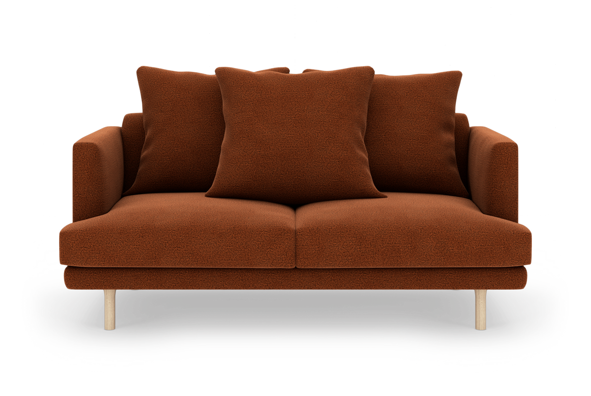Rustbrun 2-personers sofa med tre løse puder og lyse træben, frilagt på hvid baggrund.