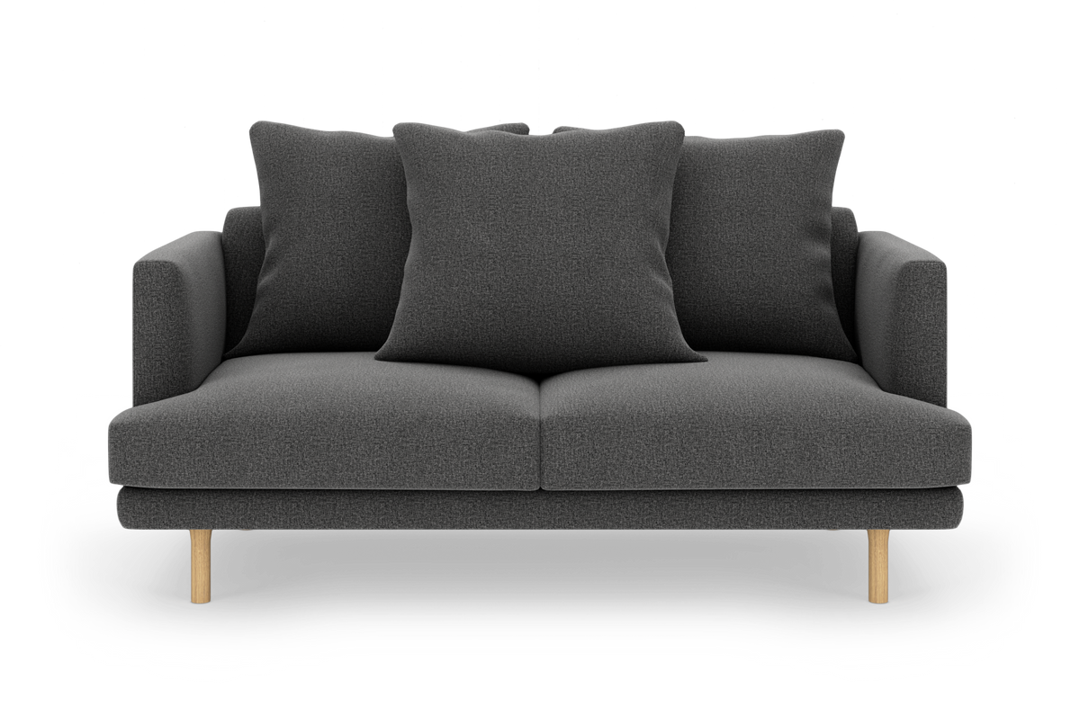 Mørkegrå 2-personers sofa med tre store rygpuder og lyse træben, frilagt på hvid baggrund.