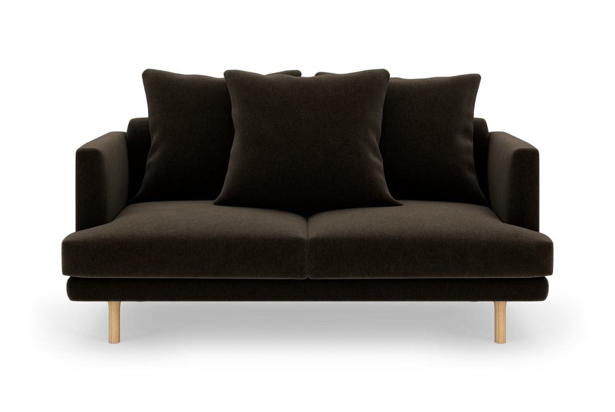 Mørkebrun to-personers sofa med tre store puder og lyse træben, frilagt på hvid baggrund.