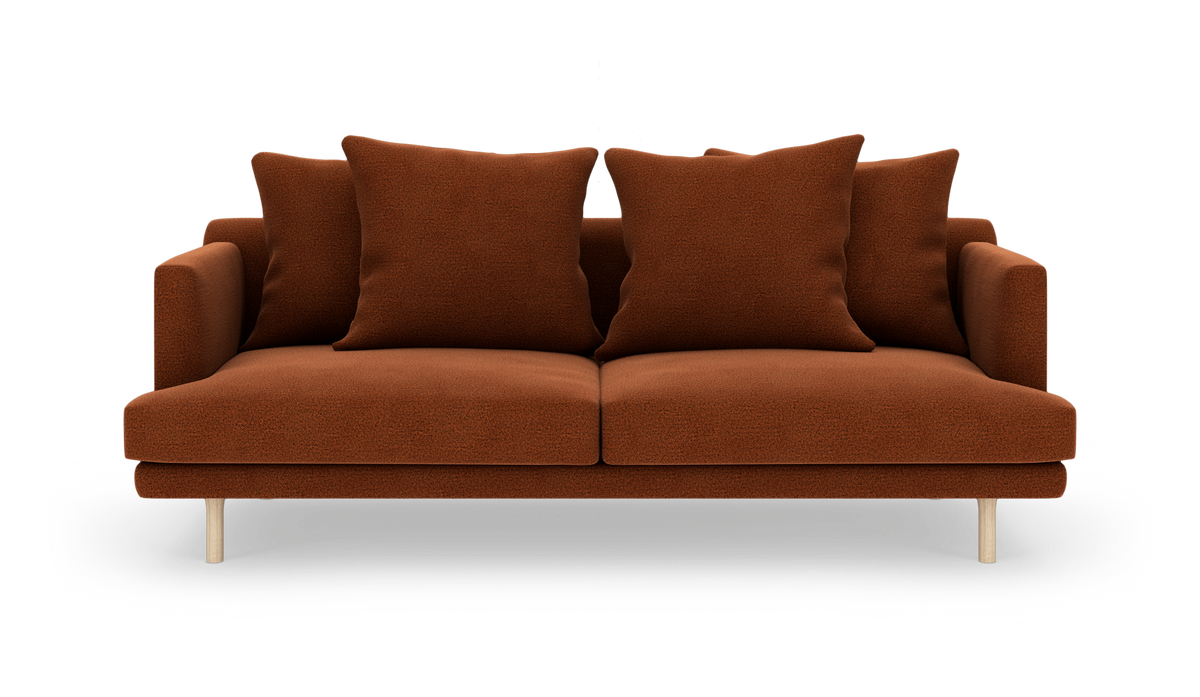 Brun 2-personers sofa med fire store puder og lyse træben på hvid baggrund.