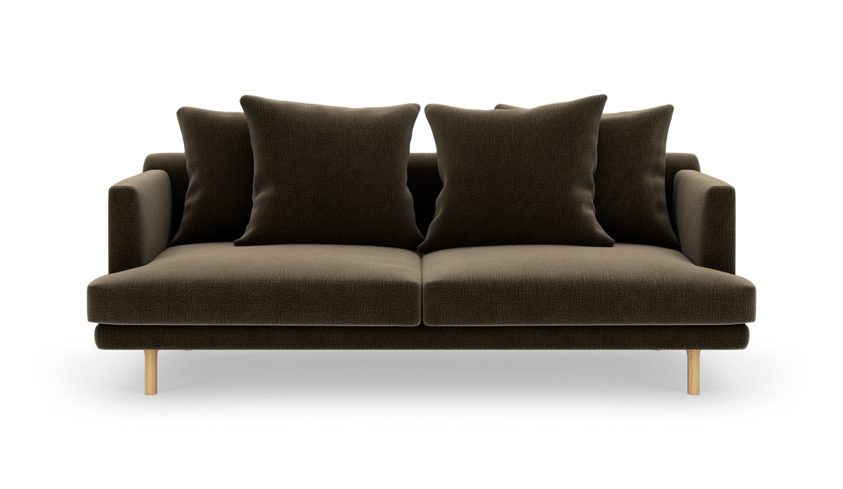 Mørkebrun sofa med fire store puder og lyse træben, fritlagt på hvid baggrund.