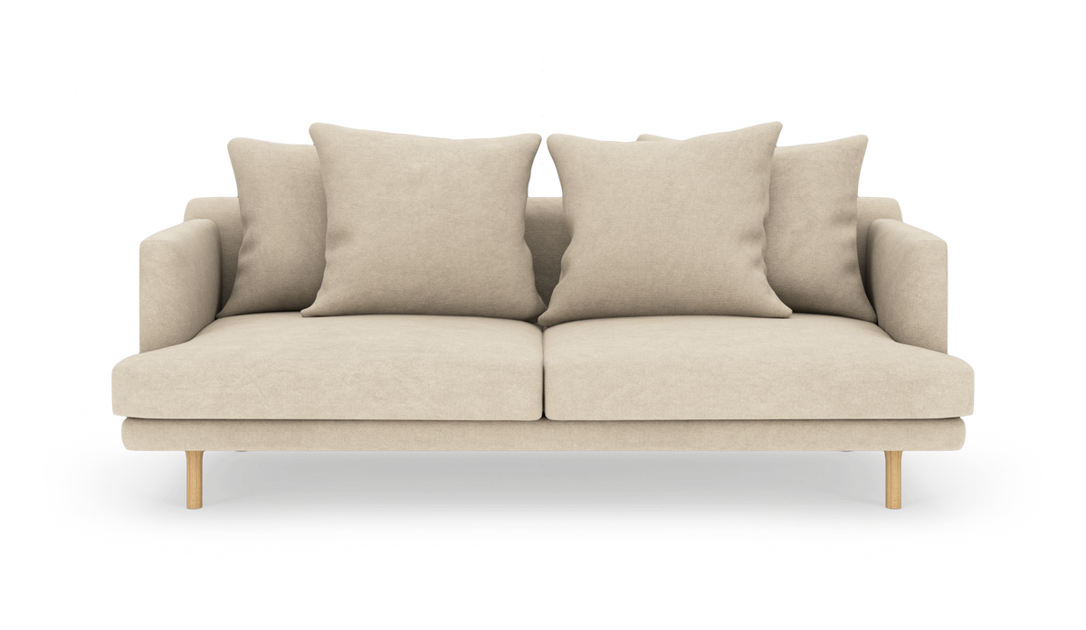 Beige sofa med fire store puder og træben, frilagt på hvid baggrund.