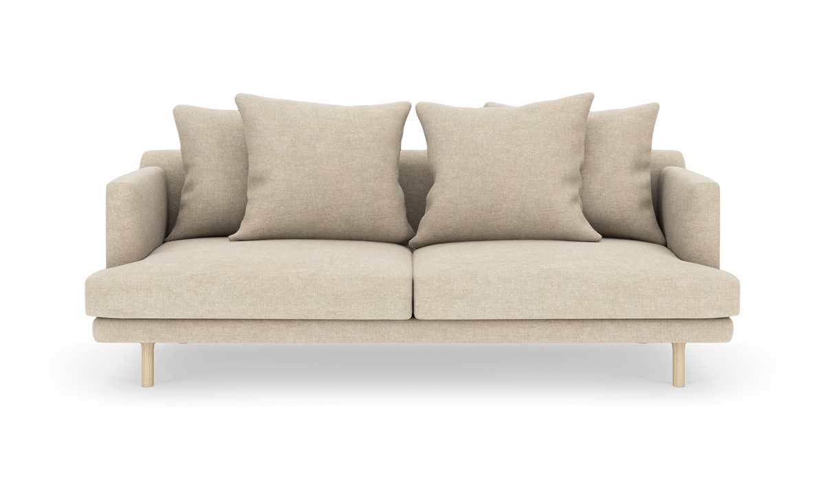 Beige sofa med fire store puder og træben, frontvisning på hvid baggrund.