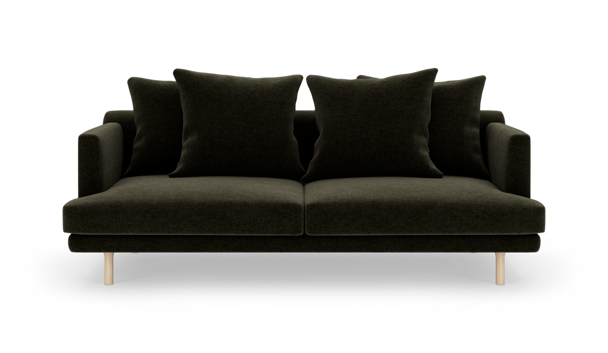 Mørkegrøn to-personers sofa med fire store puder og lyse træben, frontvisning.