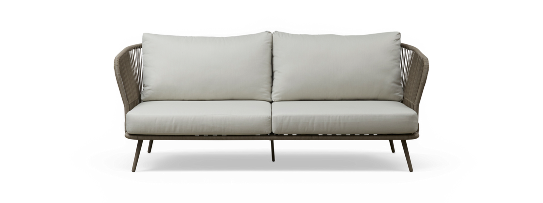 Lys beige 2-personers sofa med høje ryghynder, flettede rebsider og slanke metalben, frilagt på sort baggrund.