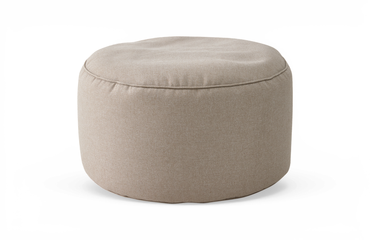 Beige rund puf/ottoman i stof på hvid baggrund.