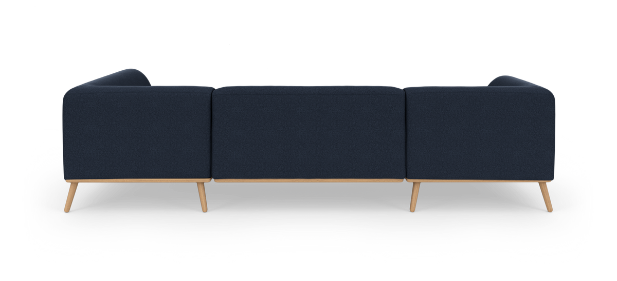 Mørkeblå tresæders sofa set bagfra med lyse træben på hvid studiebaggrund.