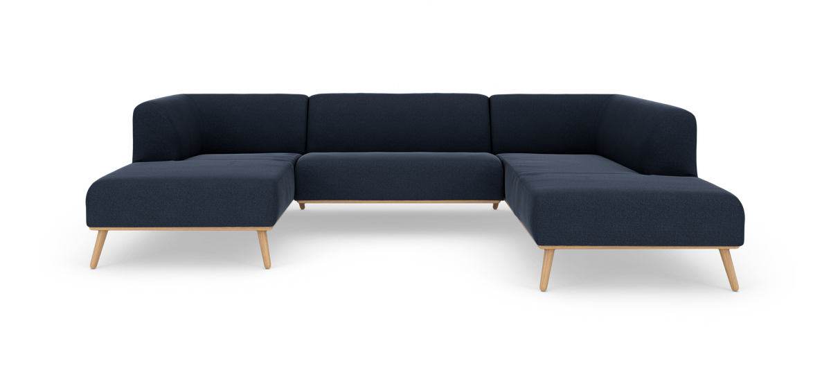 Mørkeblå modulsofa i U‑form med træben, frilagt på hvid baggrund.