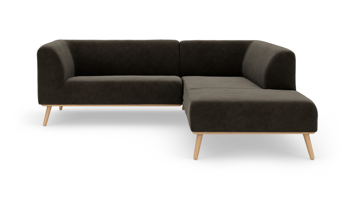 Mørkegrå hjørnesofa med chaiselong og lyse træben, frilagt på hvid baggrund.