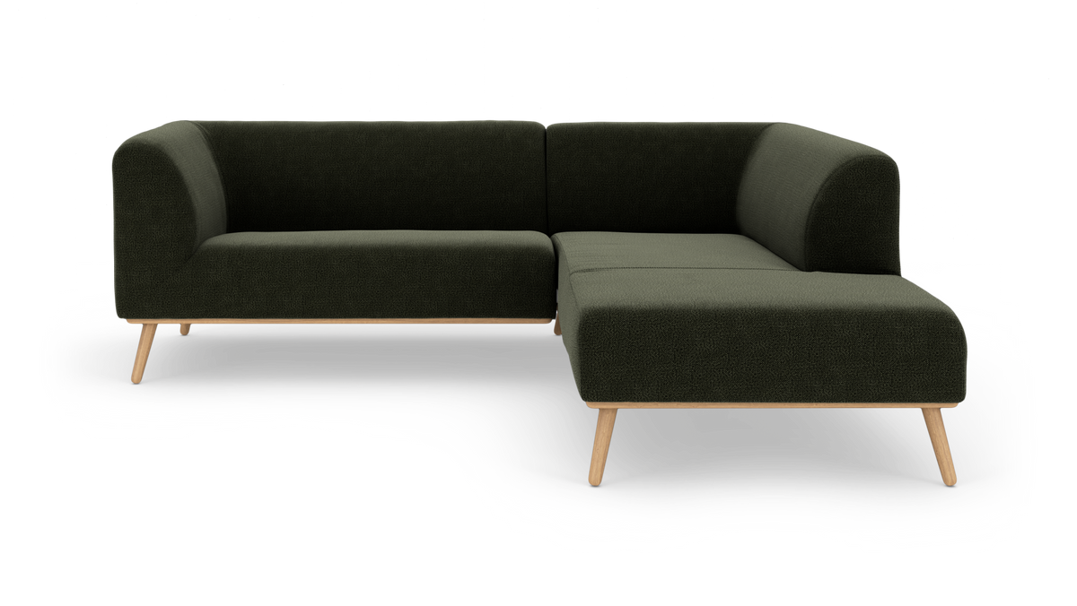 Mørkegrøn modul hjørnesofa med chaiselong til højre og træben, frilagt på hvid baggrund.