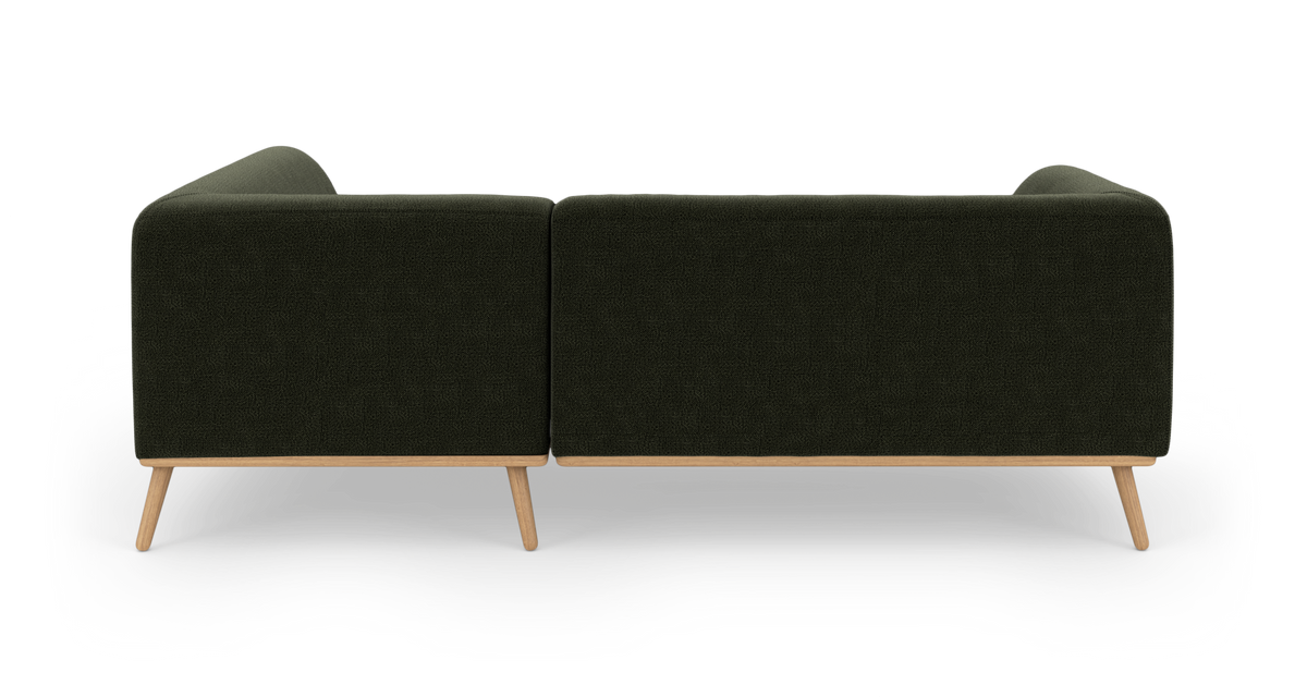 Mørkegrøn modulsofa med træben set bagfra på hvid baggrund.