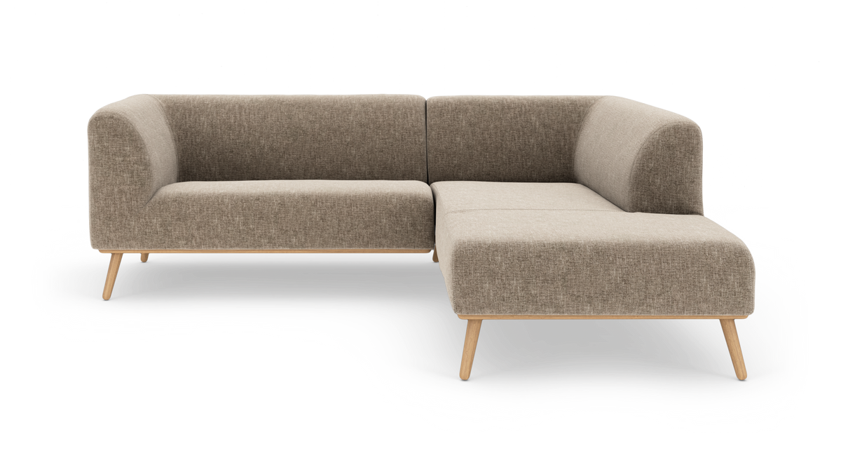 L-formet hjørnesofa i beige stof med træben og chaiselong til højre, fritlagt på hvid baggrund.
