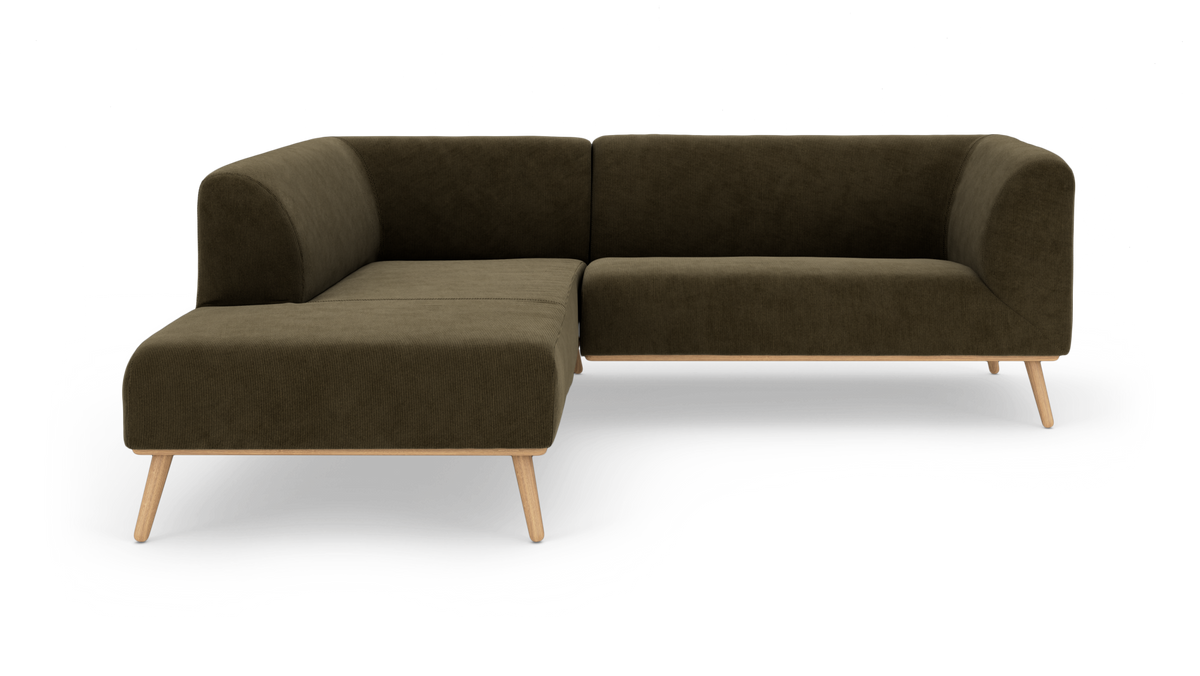 Mørk olivgrøn L‑sofa med træben, fritstående på hvid baggrund.