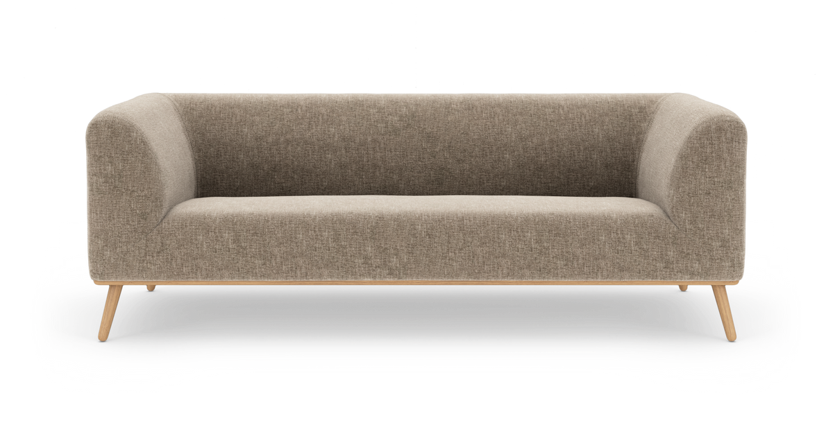 Beige stofsofa med afrundede hjørner og træben, frontvisning i studielys.