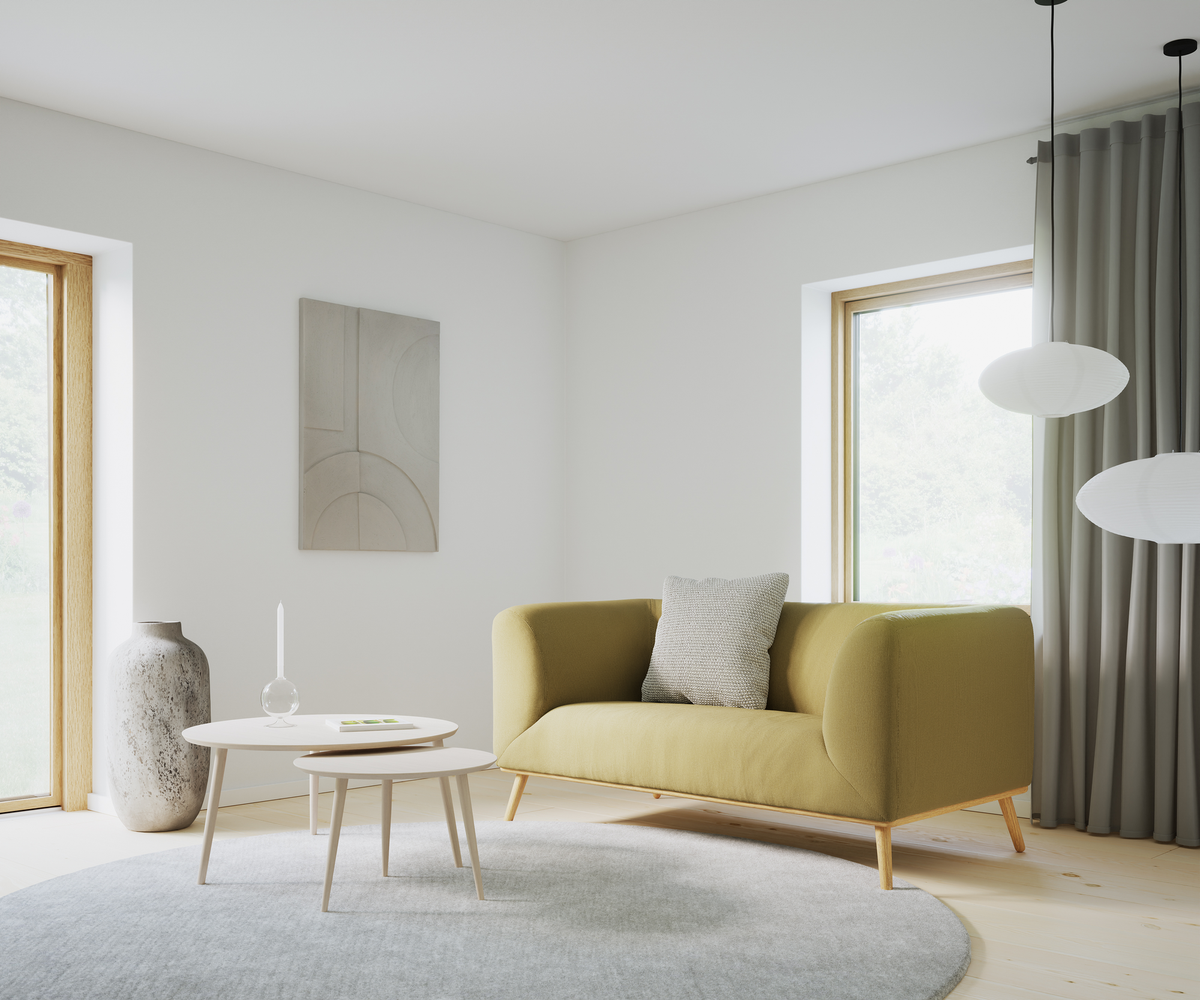Lys skandinavisk stue med olivengrøn sofa, runde hvide sofaborde, gråt rundt tæppe, stor keramikvase, abstrakt vægkunst og papirpendler ved store vinduer med gardiner.