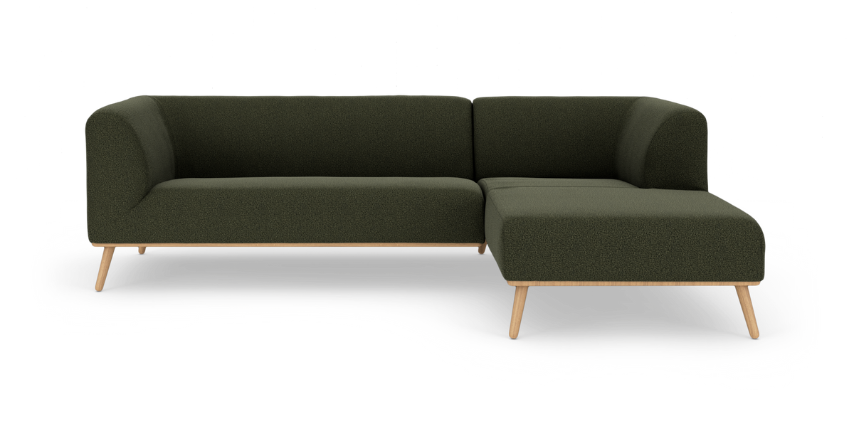 Mørkegrøn hjørnesofa med træben, frilagt på hvid baggrund.
