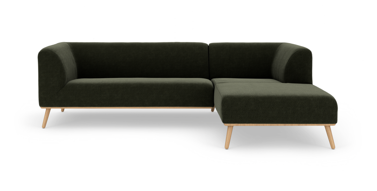 Mørkegrøn hjørnesofa med chaiselong til højre og træben, frilagt på hvid baggrund.