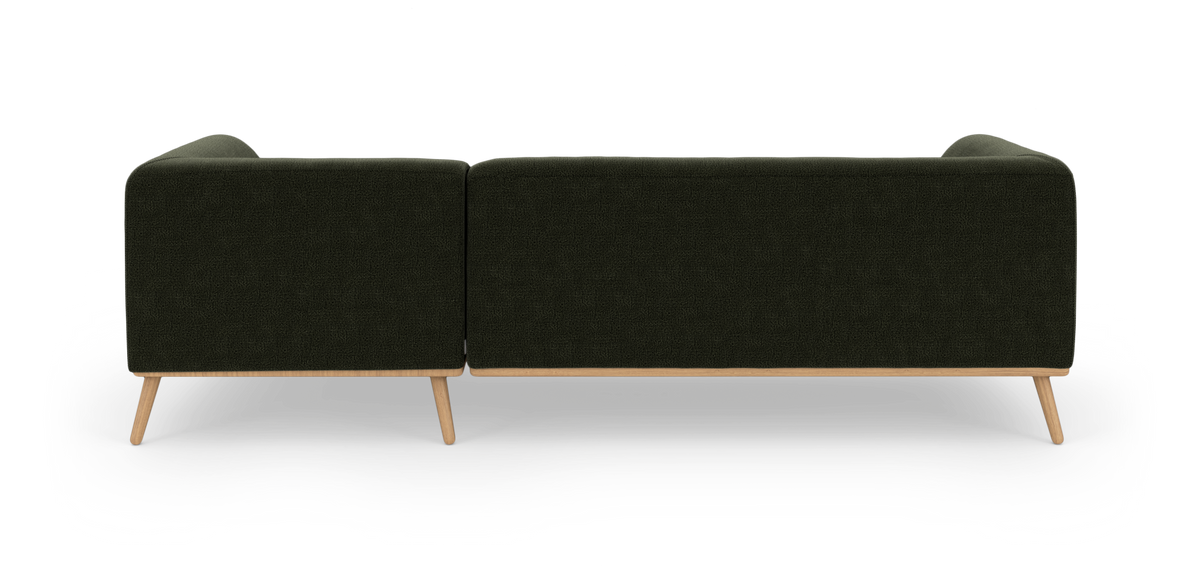Mørkegrøn sofa set bagfra på studiebaggrund med træben.