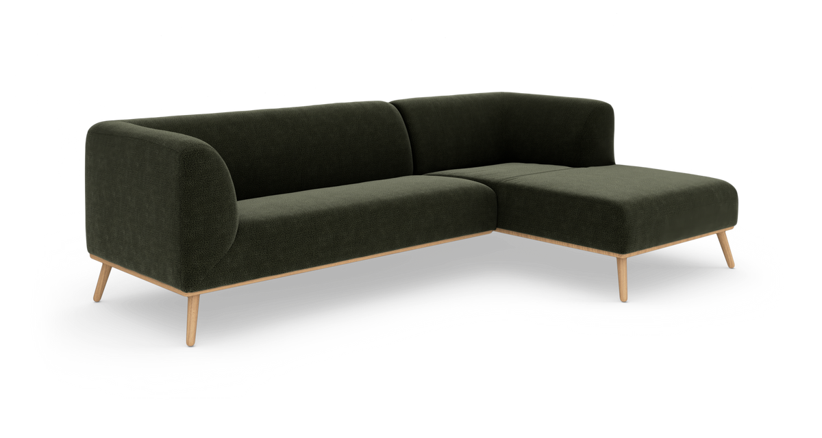 Mørkegrøn hjørnesofa med chaiselong og træben, frilagt på hvid baggrund.