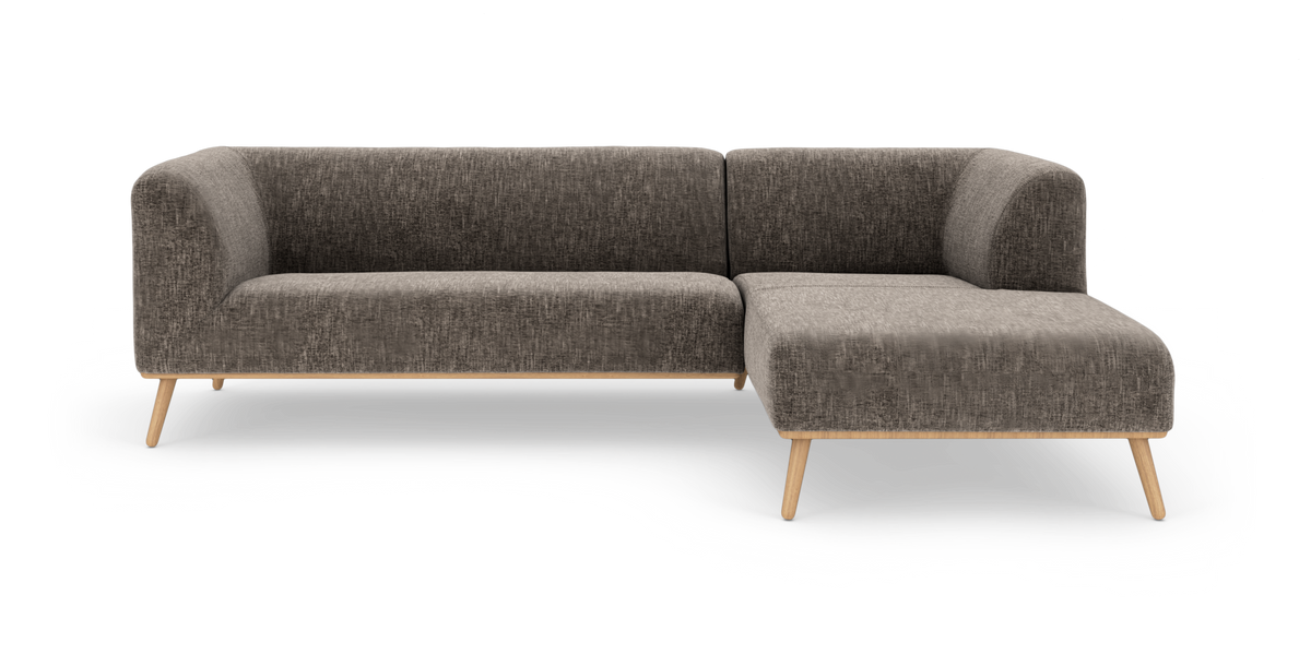 Mørkegrå L‑formet hjørnesofa med chaiselong til højre og lyse træben, frilagt på hvid baggrund.