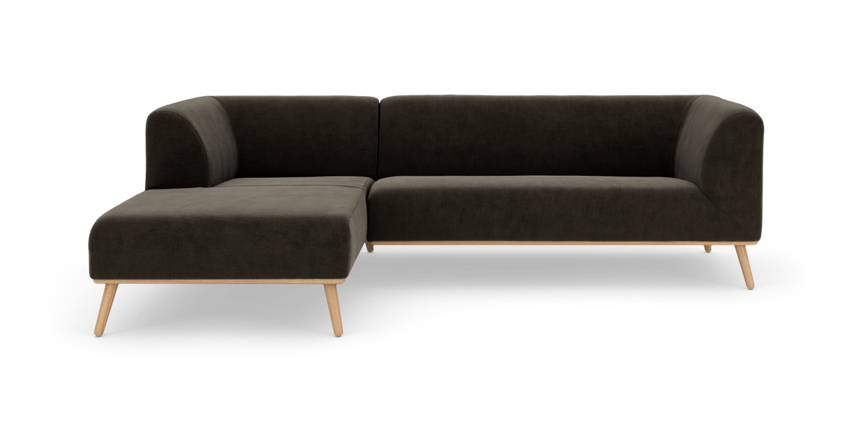 Mørkegrå L-sofa med venstrevendt chaiselong og lyse træben, frilagt på hvid baggrund.