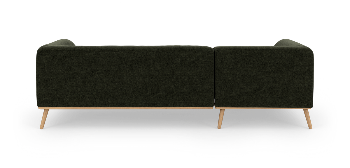 Mørkegrøn modulsofa med lyse træben set bagfra, frilagt på hvid baggrund.