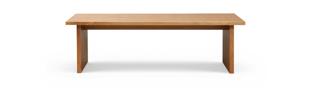 Rektangulær bænk i massiv eg med riflede ben, frilagt mod sort baggrund, set forfra.