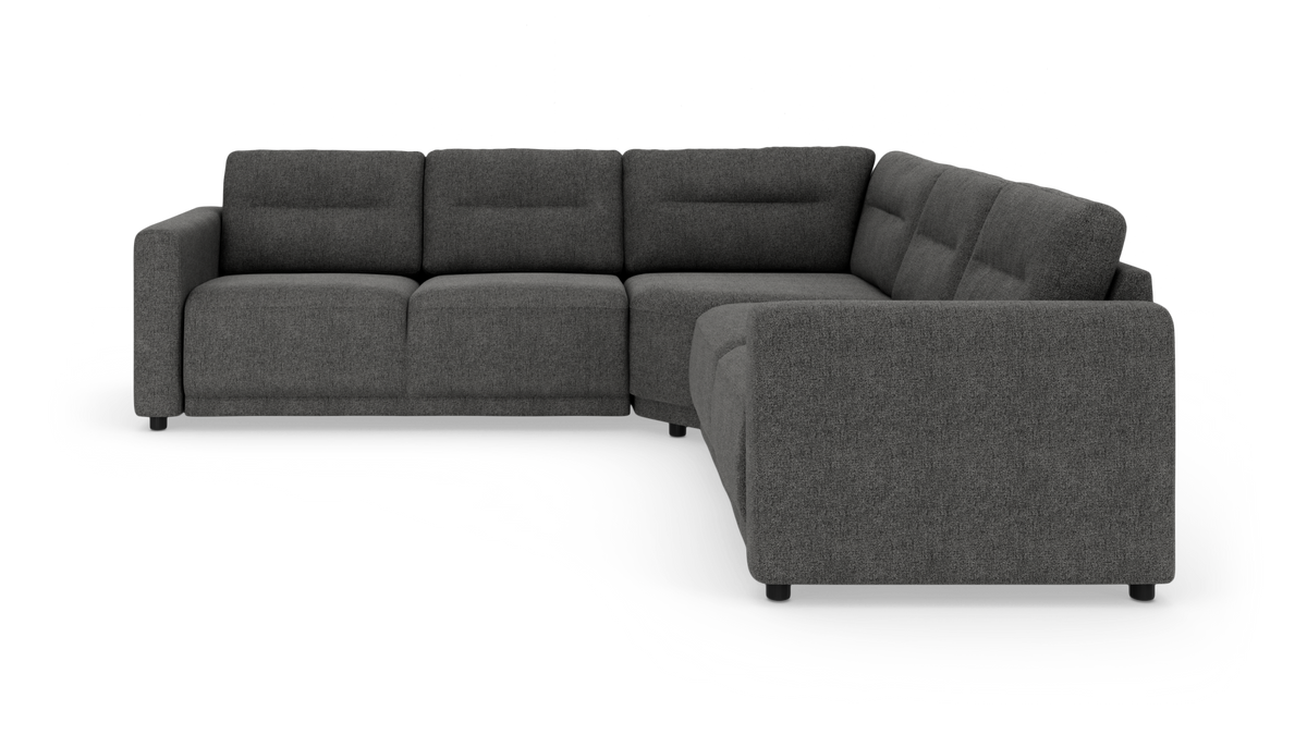 Mørkegrå L‑formet modul/hjørnesofa i stof med brede armlæn og polstrede ryghynder, frilagt på hvid baggrund.