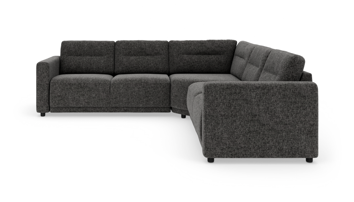 Mørkegrå L‑formet modulsofa i tekstil, vist i studie mod hvid baggrund.