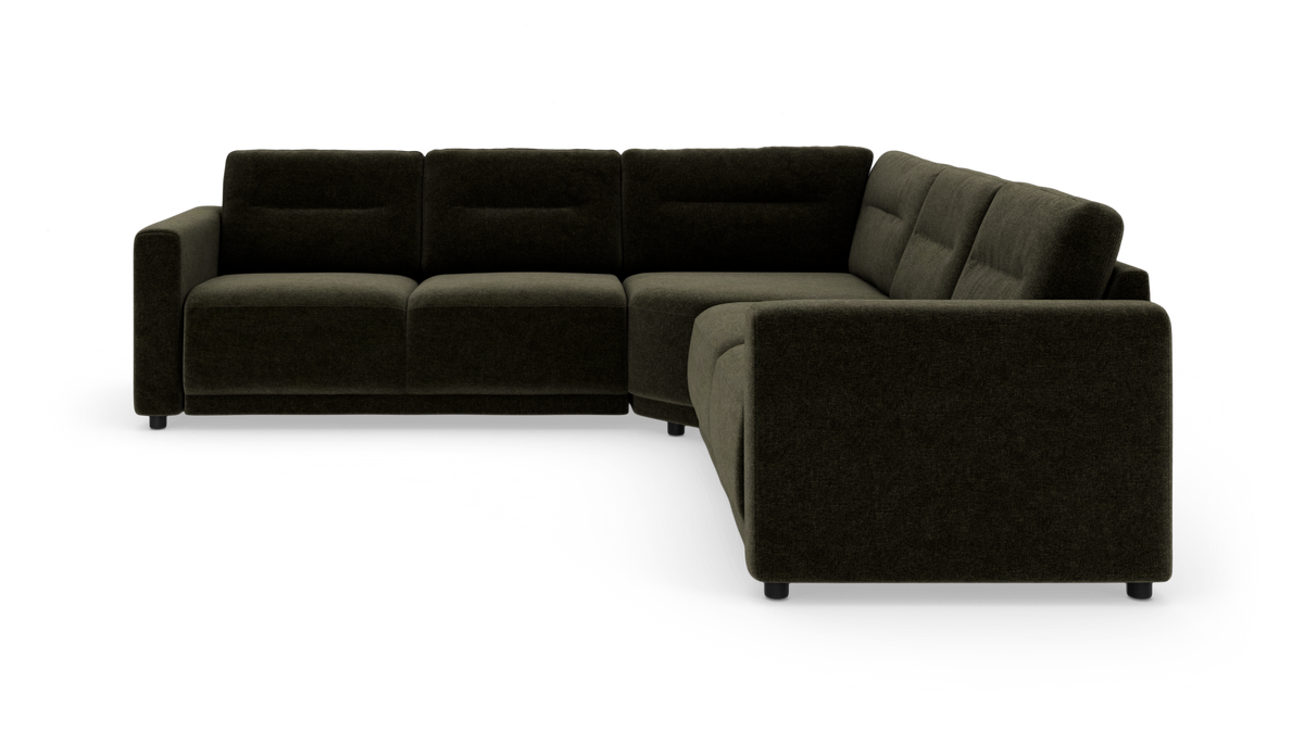 Mørkegrøn L‑formet modulsofa i stof, moderne hjørnesofa set skråt forfra i studiemiljø.