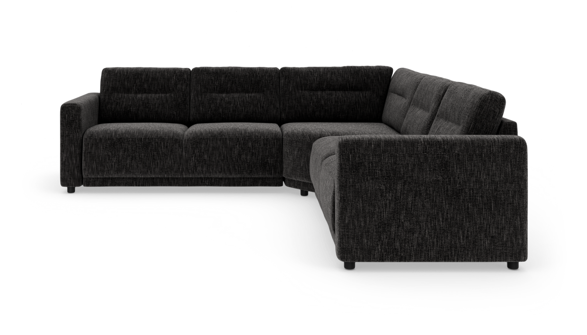 Mørkegrå L‑formet modulsofa i stof, vist i studie mod hvid baggrund.