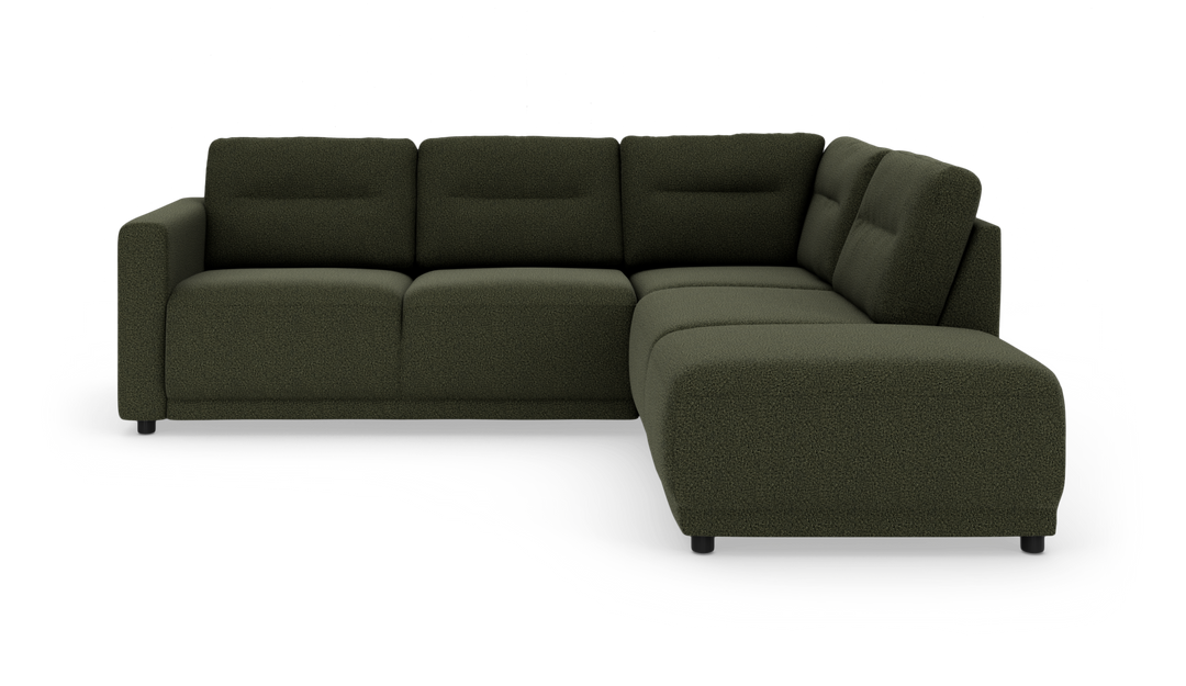 Mørkegrøn L-formet hjørnesofa med chaiselong til højre, bløde kraftige hynder og korte sorte ben i studielys.