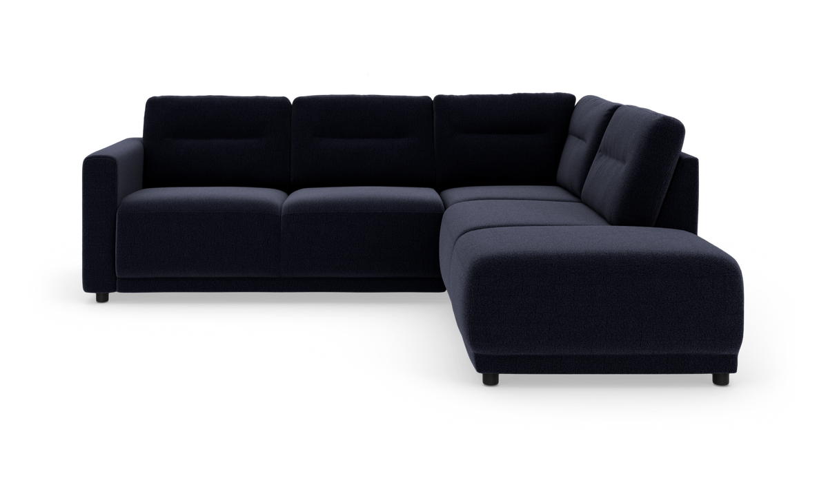 Mørkeblå L‑formet modulsofa med chaiselong til højre på hvid baggrund.