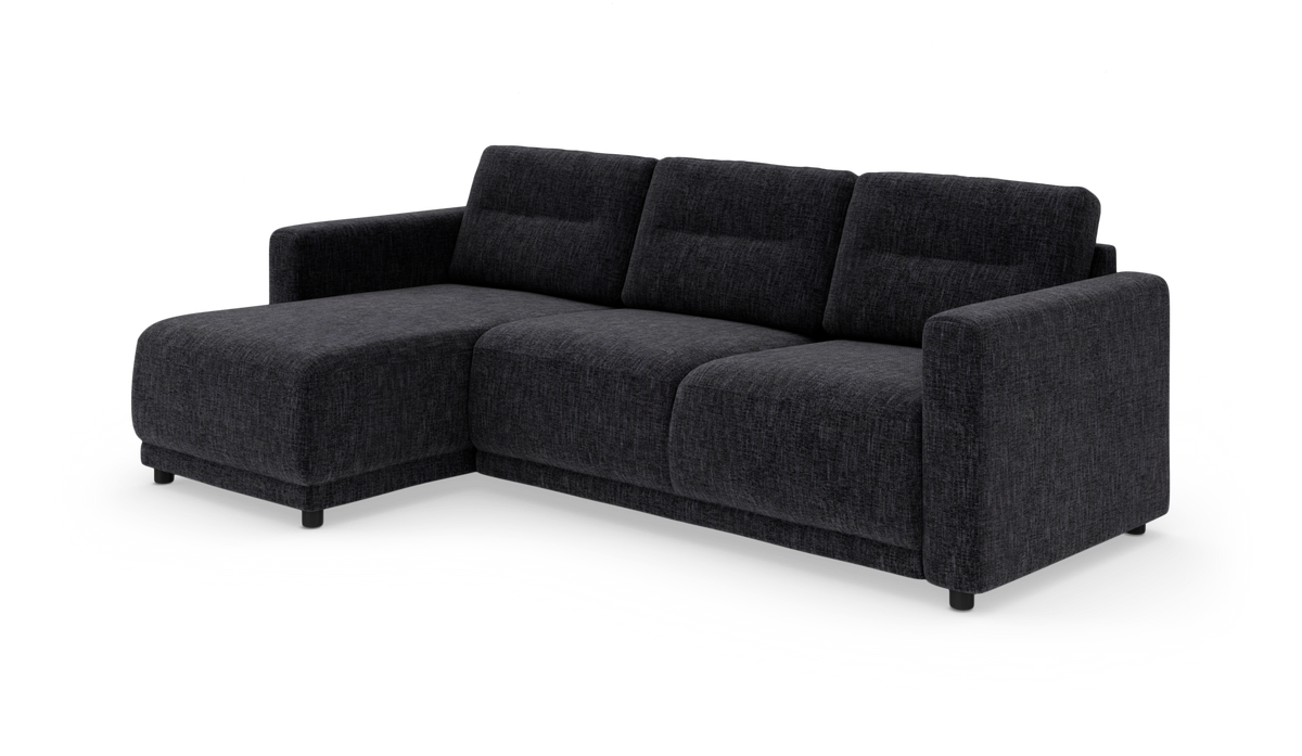 Mørkegrå L-sofa i stof med venstrevendt chaiselong, tre sæder og lige armlæn på hvid baggrund.
