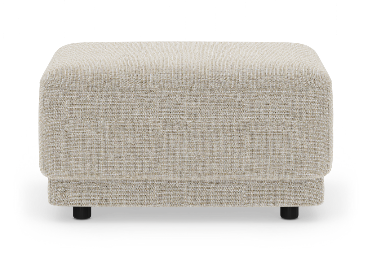 Beige rektangulær puf/ottoman i tekstil med korte sorte ben, fritlagt på hvid baggrund.