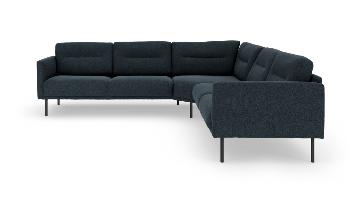 Mørkeblå hjørnesofa i stof med slanke metalben, frilagt på hvid baggrund.
