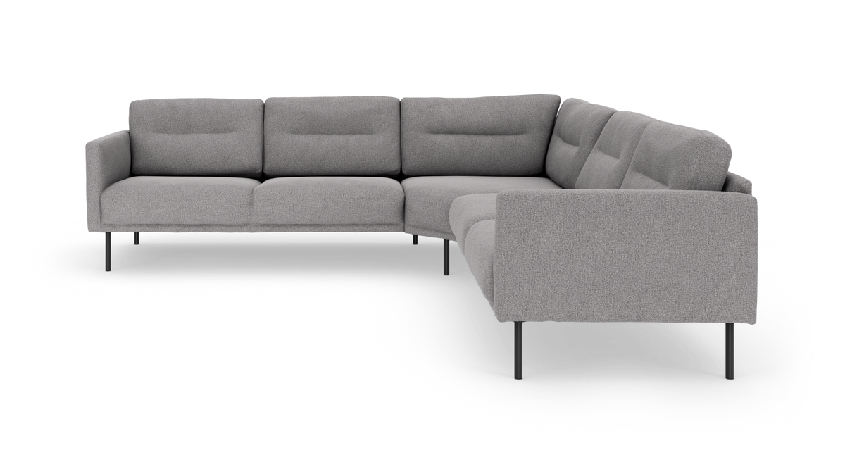 Grå L-formet modulsofa med slanke sorte ben, set forfra i vinkel på hvid baggrund.