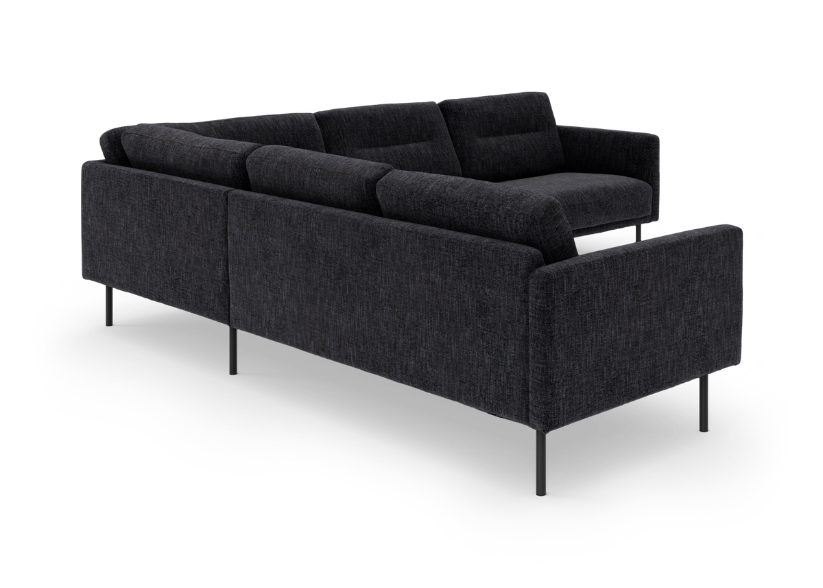 Mørkegrå modulsofa i stof med slanke metalben, set skråt bagfra på hvid baggrund.