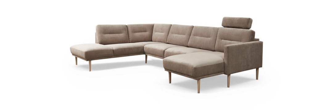 Beige L-formet modulsofa med chaiselong til venstre, højre armlæn og justerbar nakkestøtte, stofbetræk og lyse træben, fritlagt.