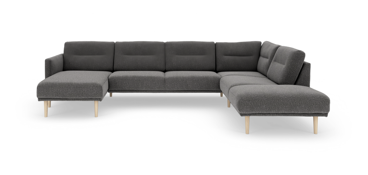 Mørkegrå modulær hjørnesofa med chaiselong til venstre og åben afslutning til højre, på lyse træben.