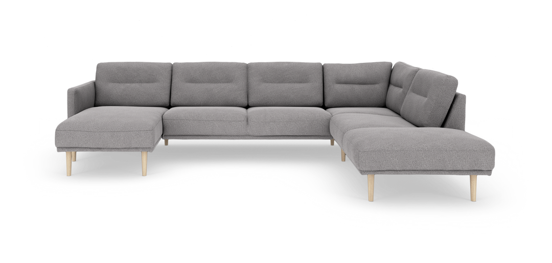 Grå modulær hjørnesofa med chaiselong og lyse træben, set forfra i studie på hvid baggrund.