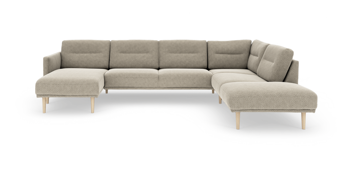 Beige L‑formet modulsofa i stof med chaiselong til venstre og åben afslutning til højre, på lyse træben.