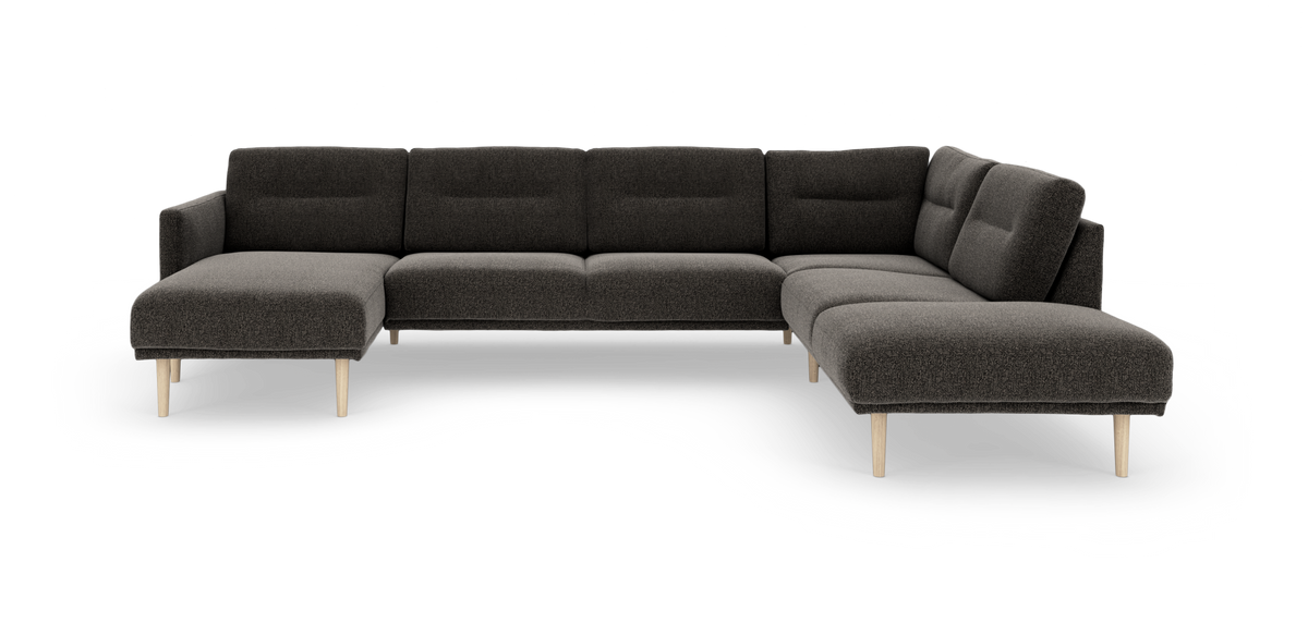 Mørkegrå modulsofa i U‑form med venstre chaiselong og højre chaiselong, slanke lyse træben, fritstående på hvid baggrund.