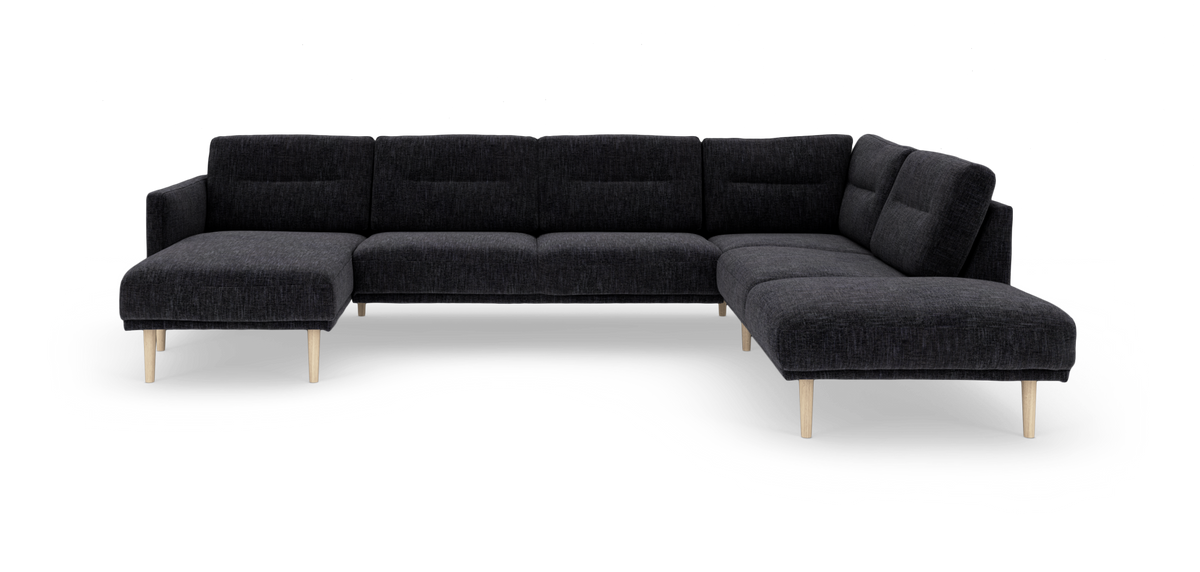 Mørkegrå modulsofa i U‑form med lyse træben, frilagt på hvid baggrund.