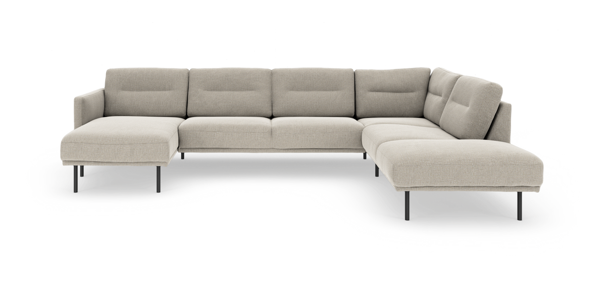 Beige modulsofa i L‑form med chaiselong og slanke metalben, frilagt på hvid baggrund.