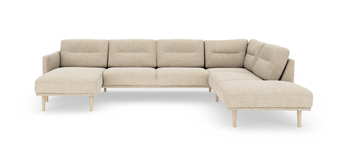 Stor hjørnesofa i beige stof med chaiselong i begge ender og lyse træben.