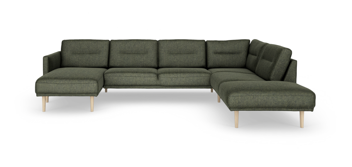 Grøn modulsofa i U‑form med chaiselong i begge ender og lyse træben.