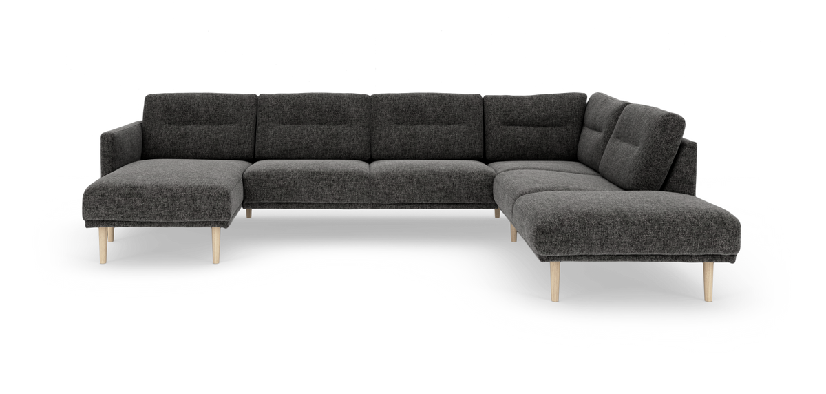 Mørkegrå modulsofa i U‑form med chaiselonger i begge ender og lyse træben, frilagt på hvid baggrund.