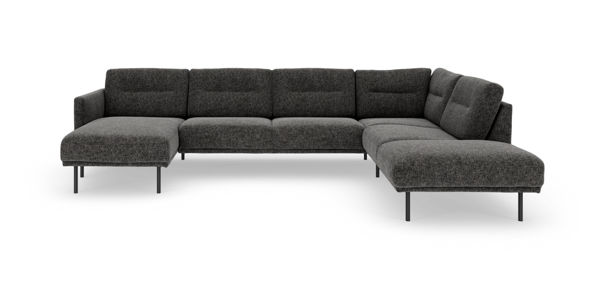 Mørkegrå U-formet modulsofa med chaiselong til venstre og divan til højre, på slanke metalben.