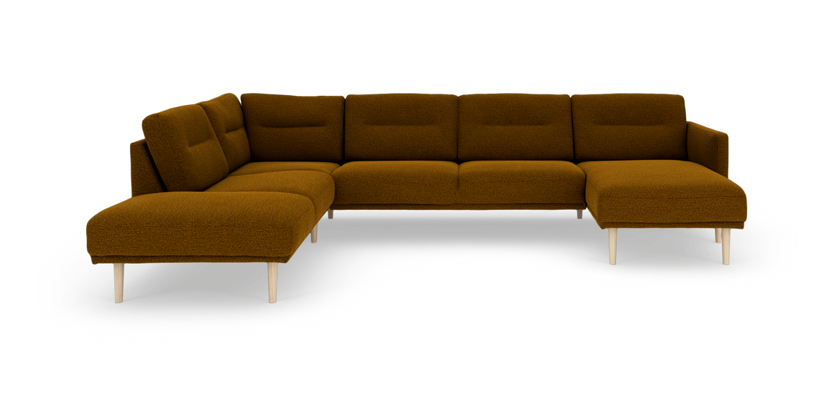 Modulær hjørnesofa i mørk okker/sennepsgul bouclé med lyse træben, frilagt på hvid baggrund.